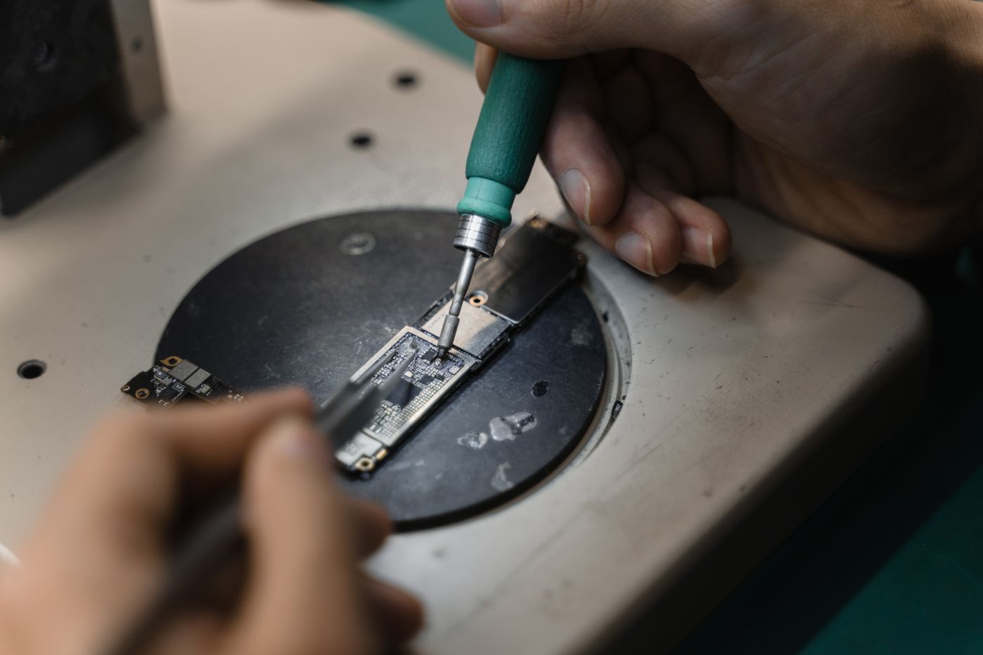 Technician soldering electronic hardware at a workbench